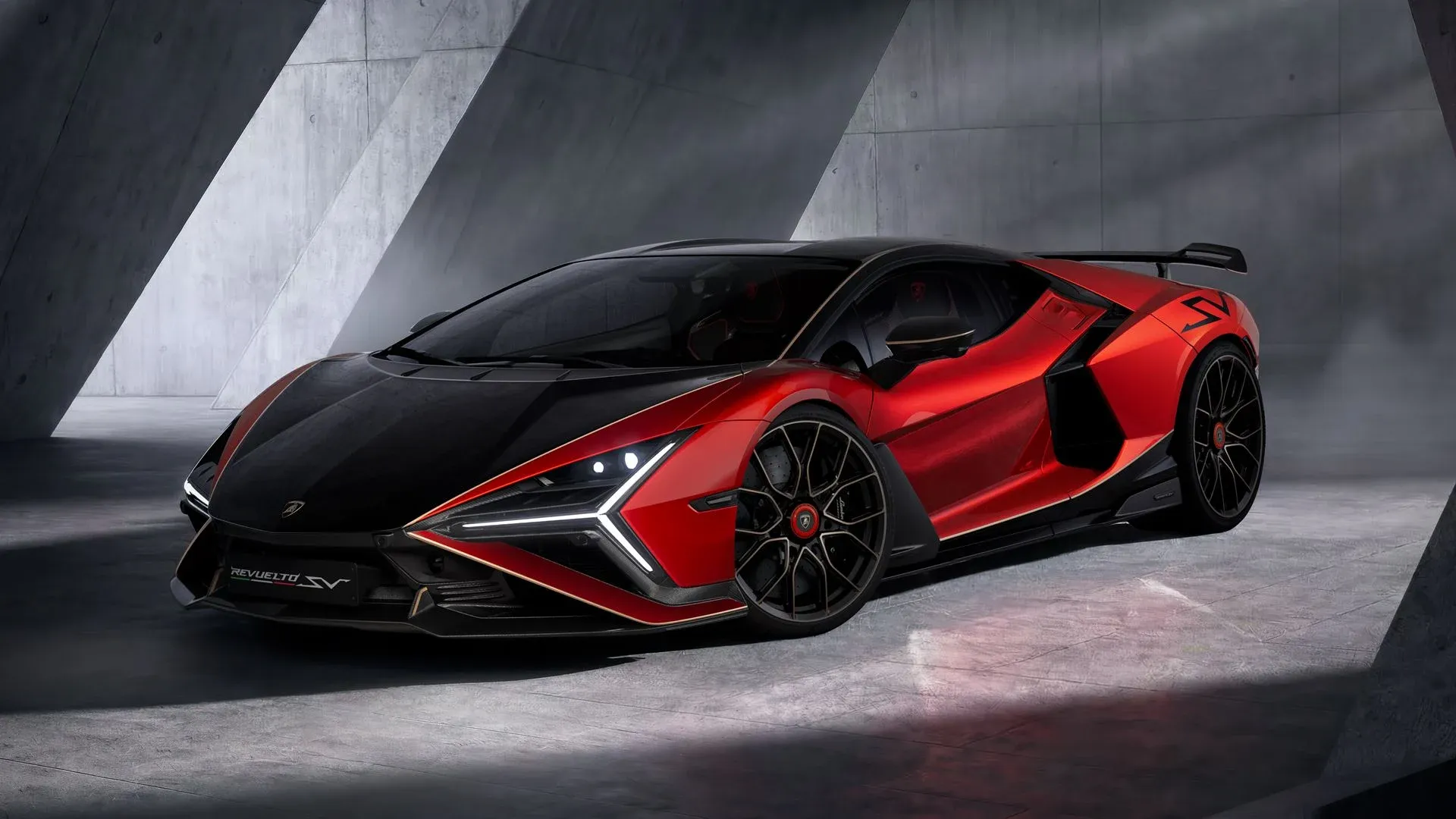 The Lamborghini Revuelto SV in red with a black carbon bonnet and gold pinstriping, seen from the front three-quarter in a concrete studio
