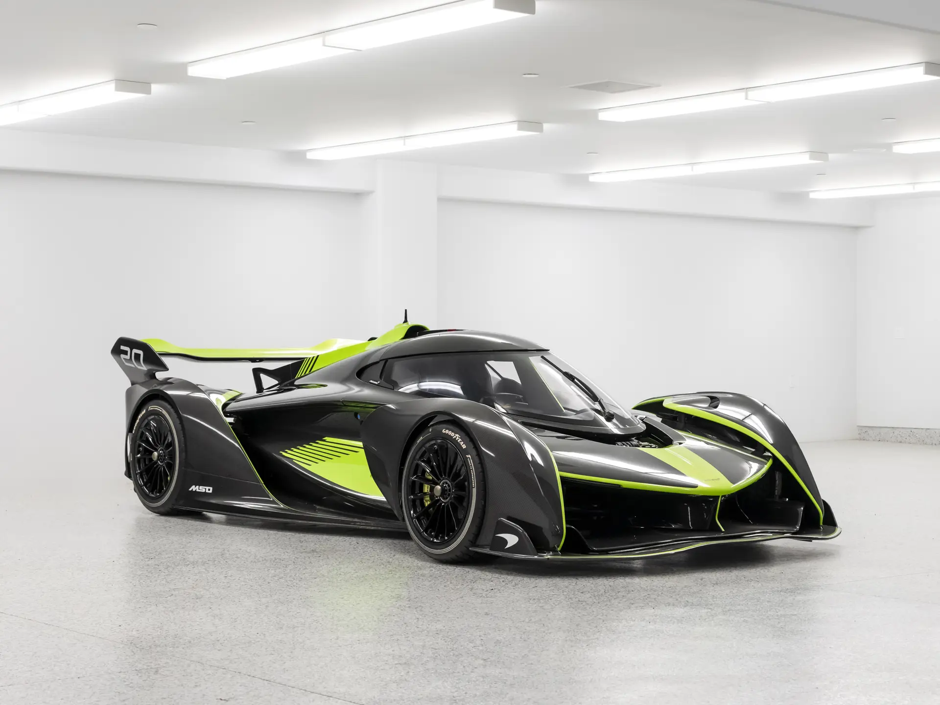 McLaren Solus GT in exposed carbon fibre with green accents, seen from the front three-quarter