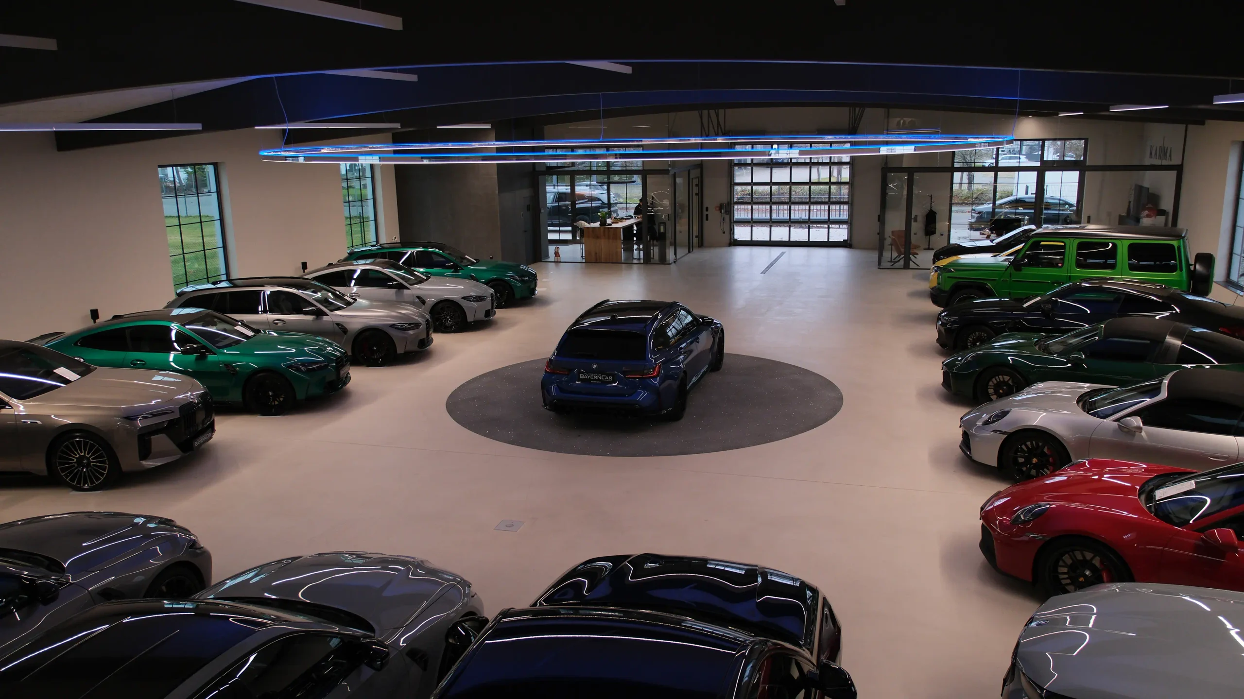 Der Showroom von BayernCar in Königsbrunn von oben, Reihen von BMW-Modellen um eine Drehscheibe unter einem Lichtring