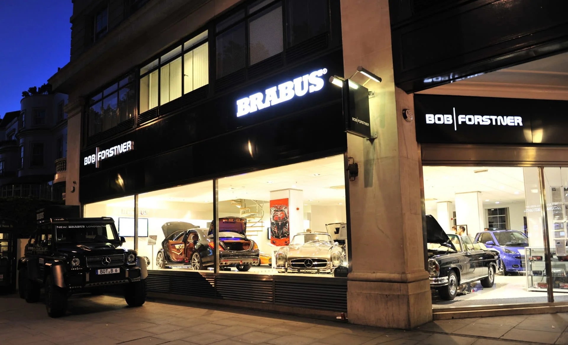 Les vitrines BRABUS et BOB FORSTNER sur Park Lane, la nuit, avec une Classe G BRABUS garée devant