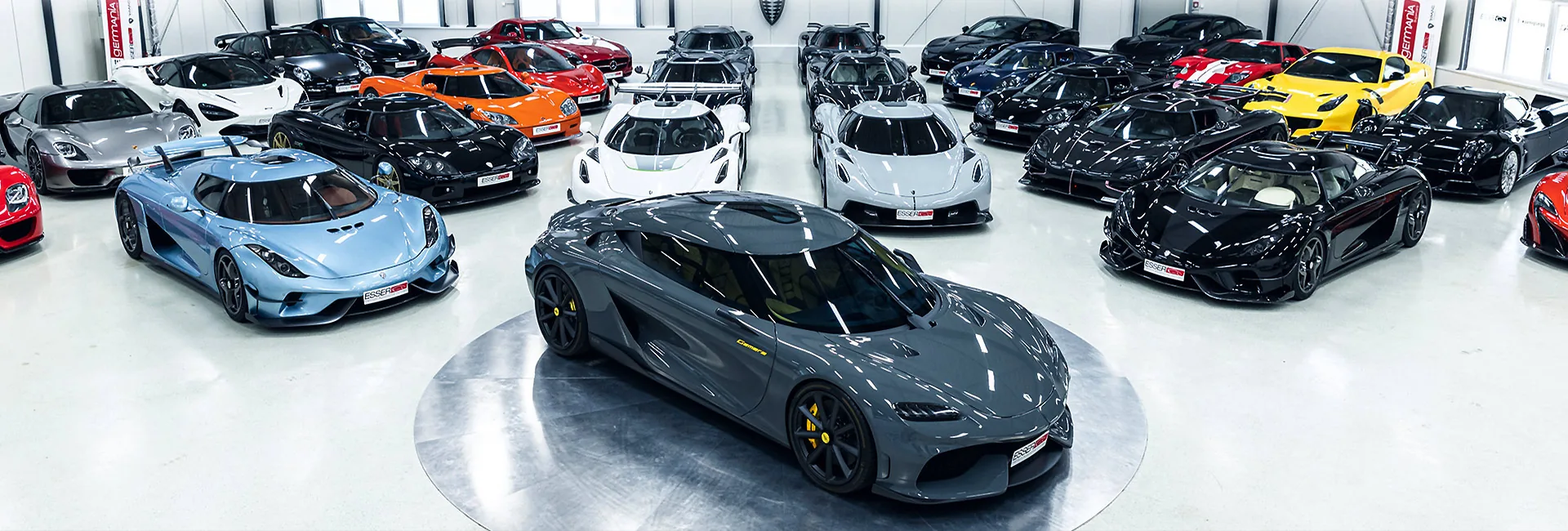 Wide view of the Esser Automotive hall with a Koenigsegg Gemera on the turntable surrounded by sports cars