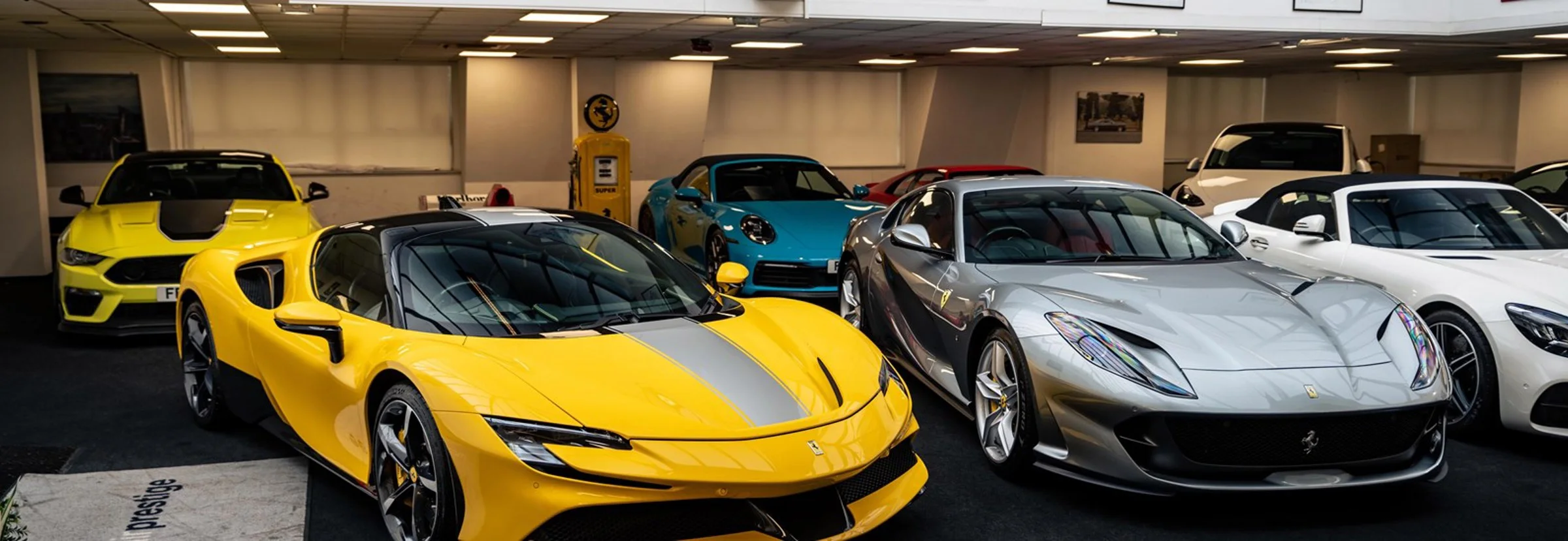 Im Showroom in Marylebone: ein gelber Ferrari SF90 Stradale und ein silberner Ferrari 812 zwischen weiteren Sportwagen