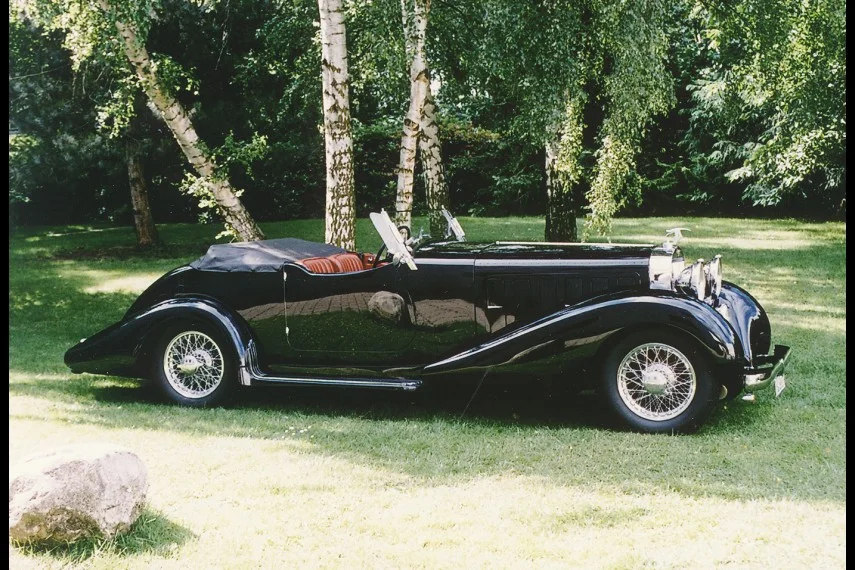 Schwarzer Hispano-Suiza Type 68 J12 von 1933 mit offenem Aufbau, Dreiviertelansicht von vorn auf einer Wiese unter Birken