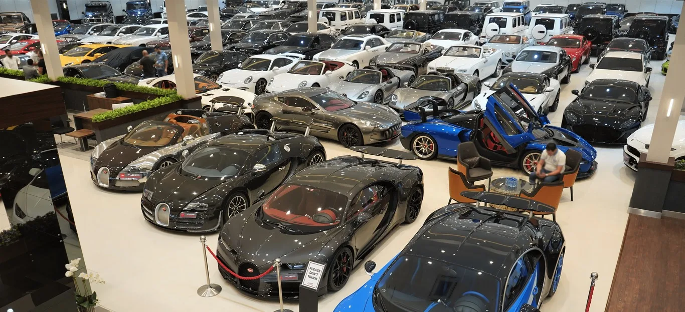 Le plateau du showroom VIP Motors à Dubaï vu d'en haut, avec des rangées de supercars et de SUV garés sous un plafond lumineux