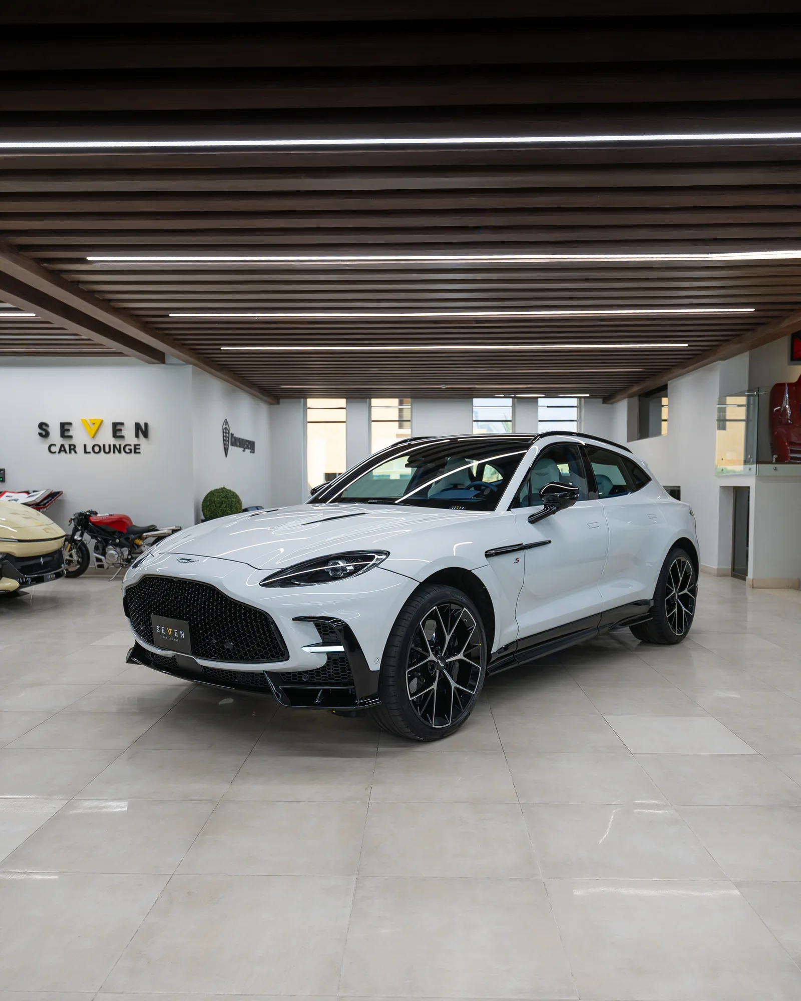 Lunar White Aston Martin DBX S, front three-quarter view in the SEVEN Car Lounge showroom in Riyadh